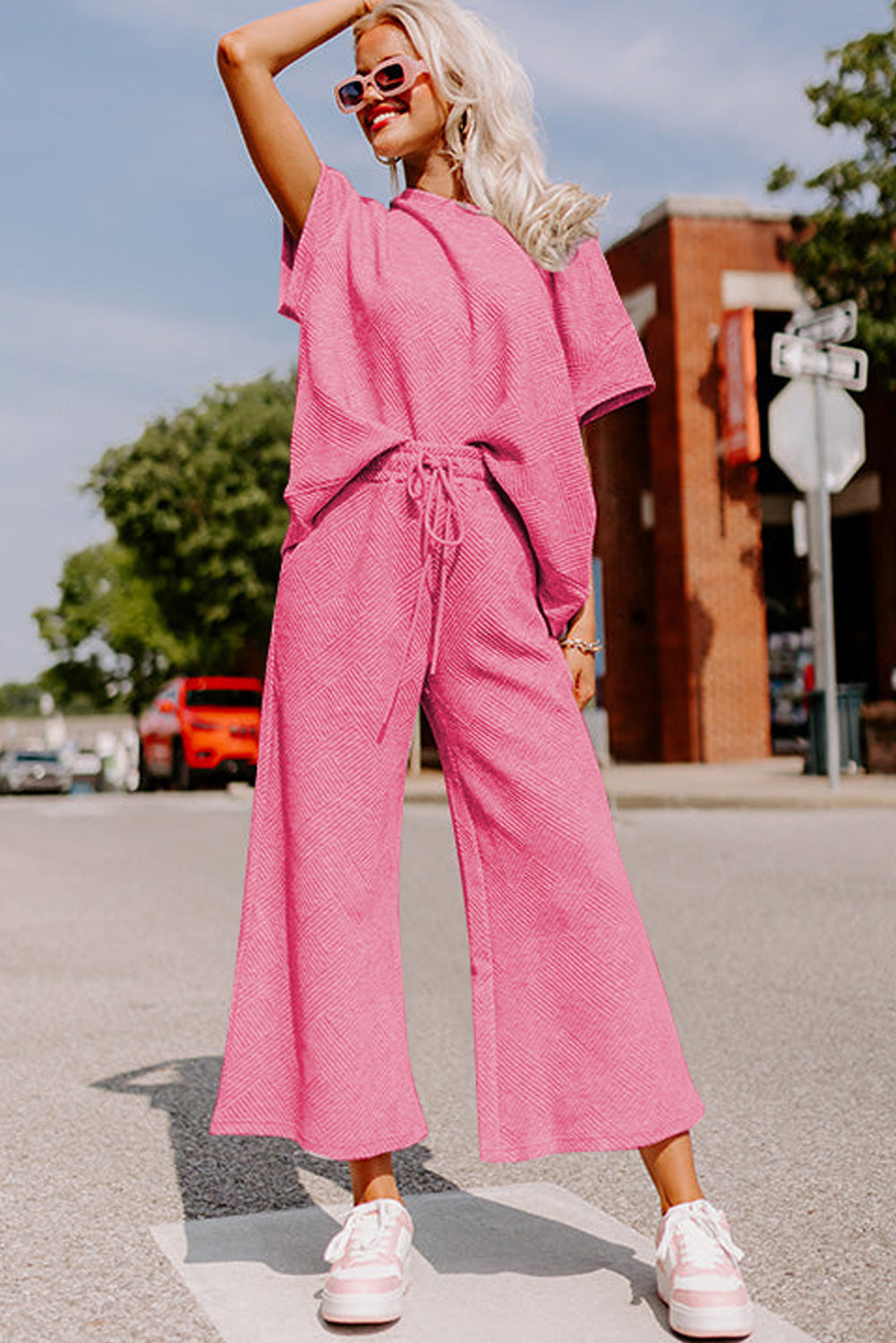 Black textured T-shirt and drawstring pants set: a versatile outfit for everyday wear. (model walking down the street)