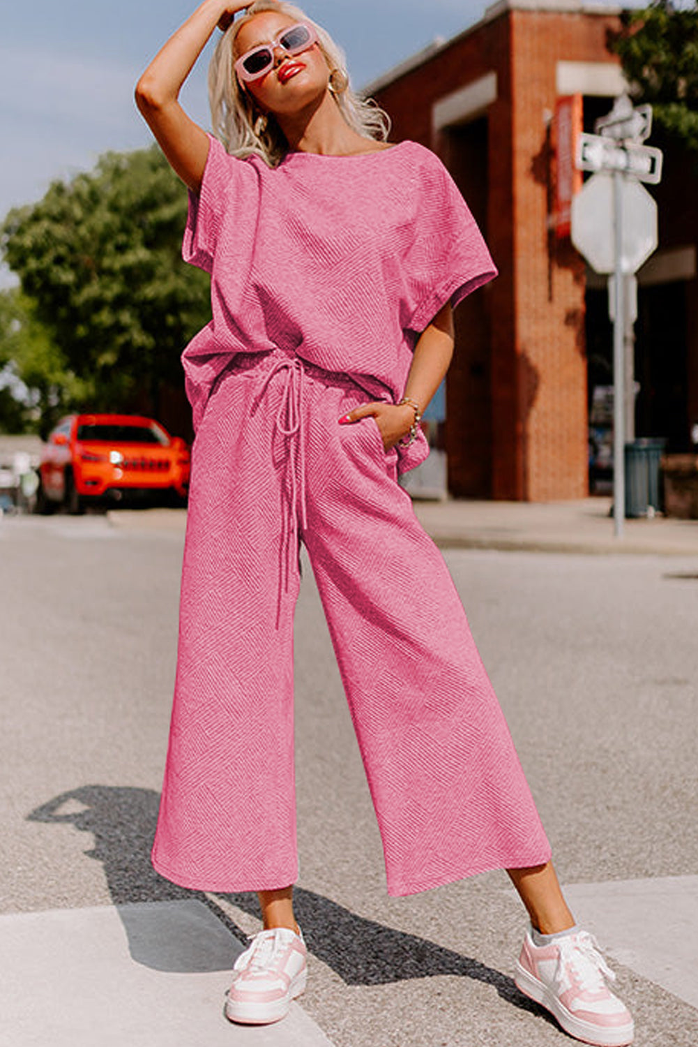 Black textured T-shirt and drawstring pants set: comfortable and stylish for running errands. (model walking with a reusable shopping bag)