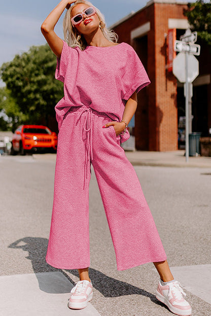 Black textured T-shirt and drawstring pants set: comfortable and stylish for running errands. (model walking with a reusable shopping bag)