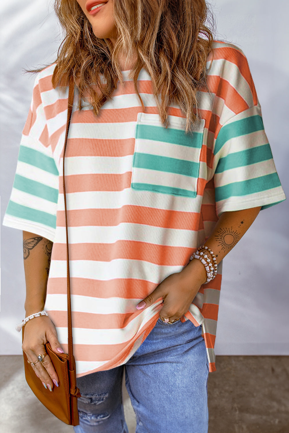 Pink striped t-shirt with drop sleeves, side slits, and a patch pocket (women's clothing).