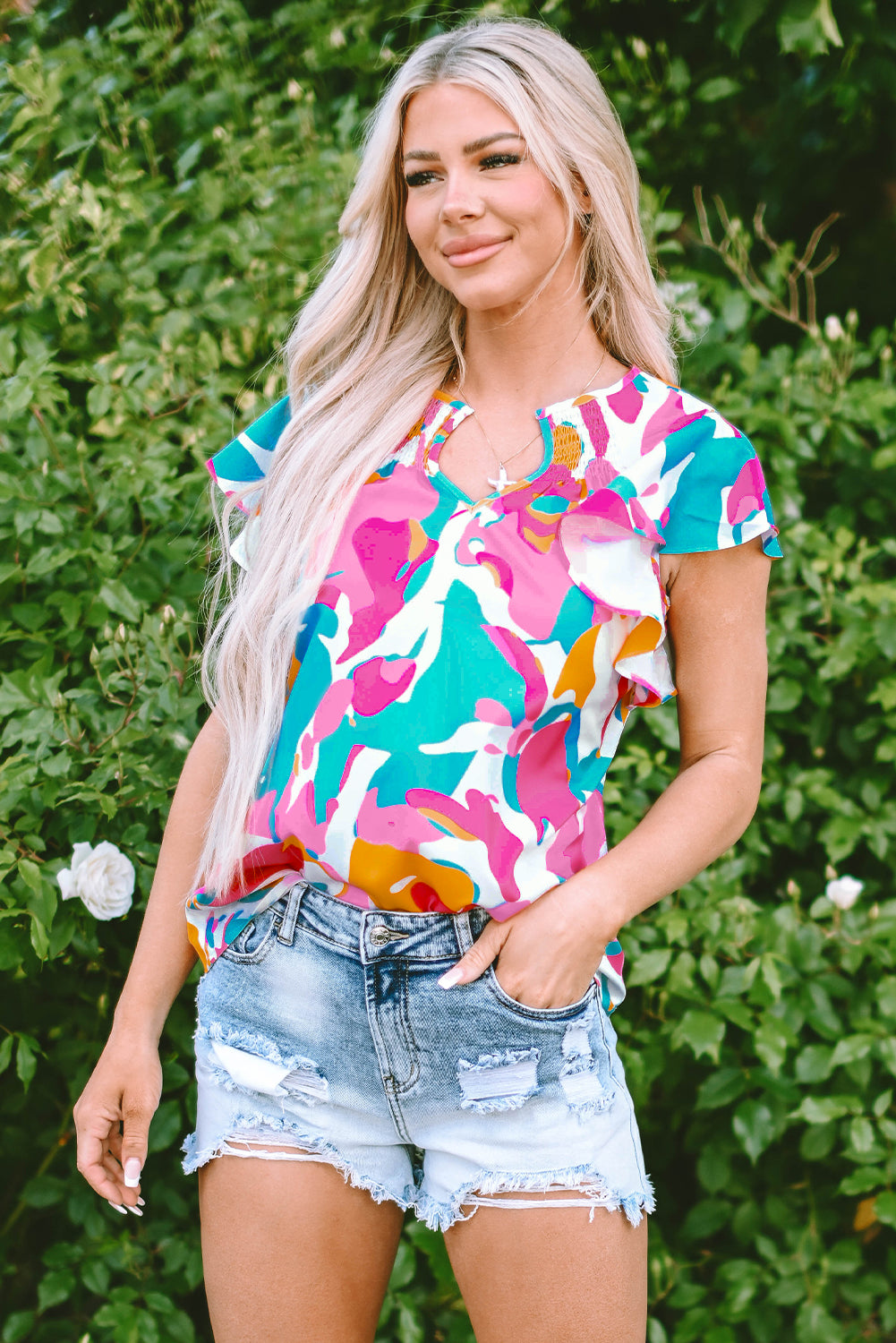 Model confidently walking in a multicolour abstract print blouse, paired with jeans (casual outfit).