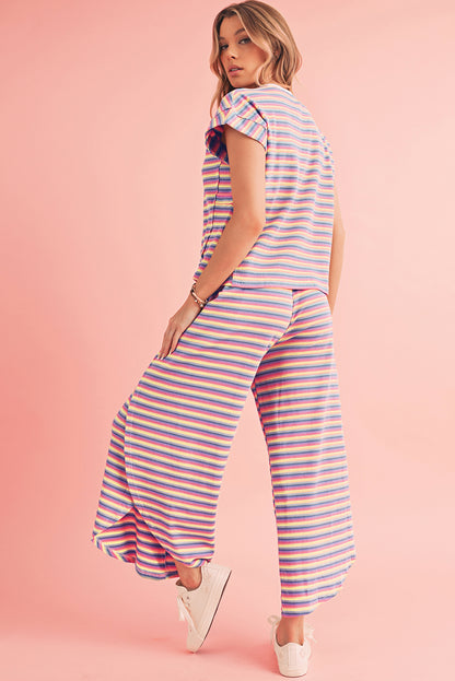 Model confidently wearing a pink striped rainbow tee with tassel drawstring wide leg pants (front view).