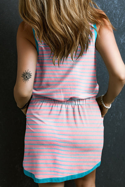 Model wearing the pink striped tank dress, showcasing the relaxed silhouette, drawstring waist, and pockets (front view).