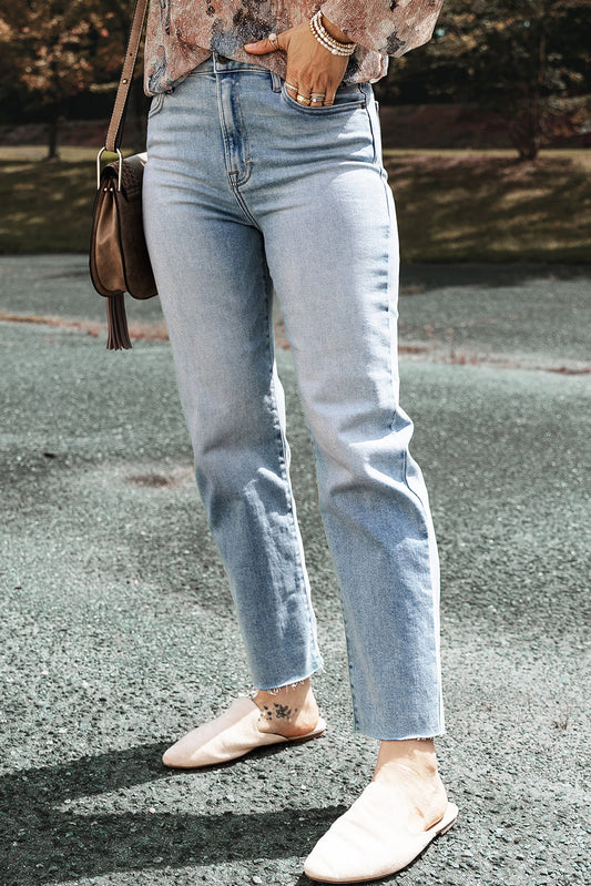 Model wearing light blue acid wash straight leg jeans with raw edge (front view).