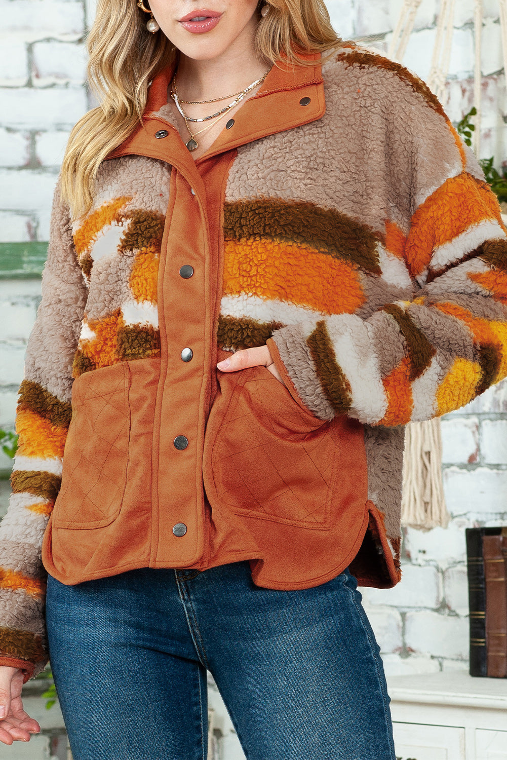 Brown striped and geometric fleece jacket with quilted patch pockets hanging neatly on a hanger.