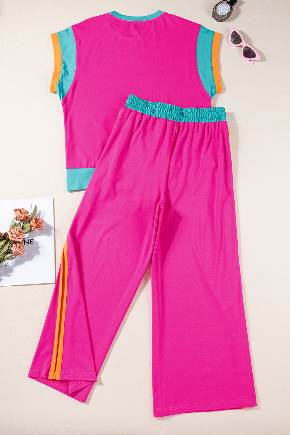 Close-up of the wide-leg silhouette of the strawberry pink pants.