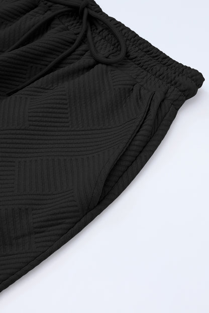 Black textured T-shirt and drawstring pants set: a versatile essential.