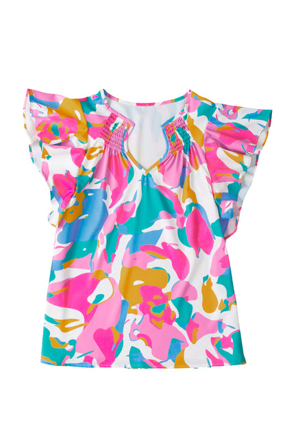 The multicolour abstract print blouse hanging on a hanger in a well-lit room.