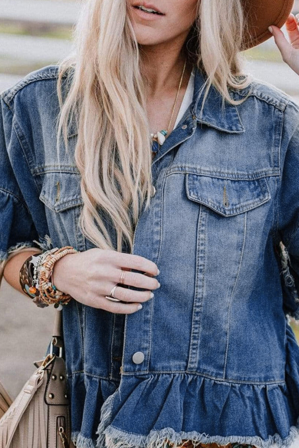 Peacock blue denim jacket with short bell sleeves, raw edges, and a relaxed fit (women's jacket).