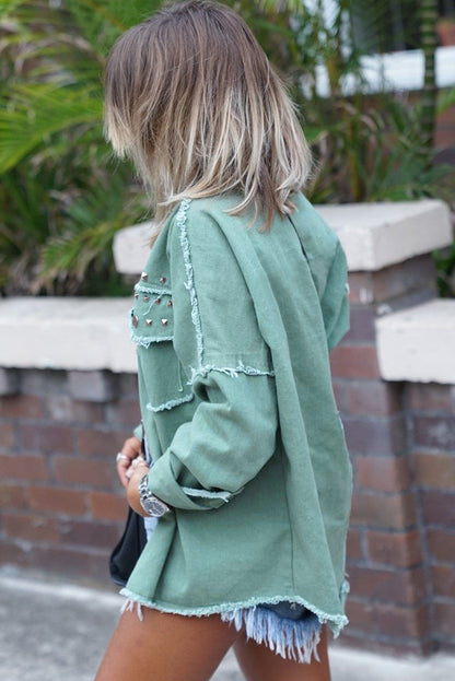 Model wearing a green frayed trim denim jacket with rivets, showcasing its edgy and stylish look (front view).