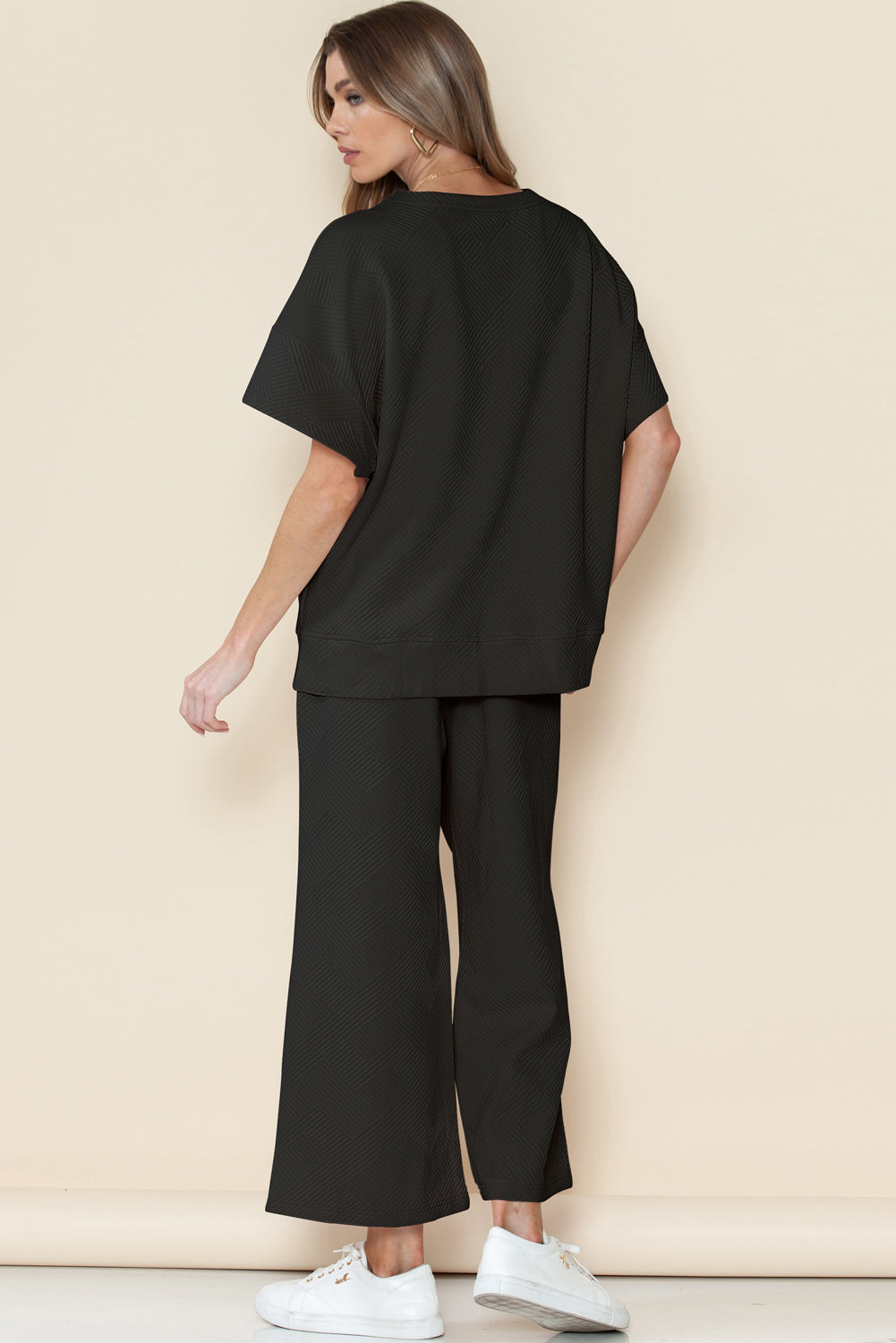 Close-up of black textured fabric on T-shirt and drawstring pants set.