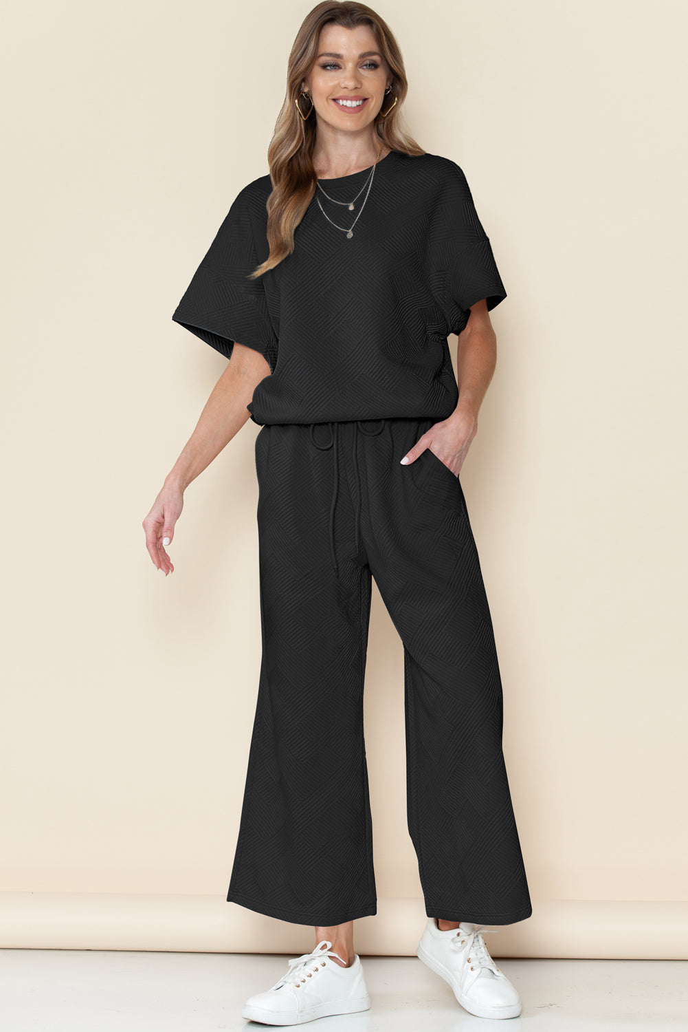 Black textured T-shirt and drawstring pants set styled for a casual outing.