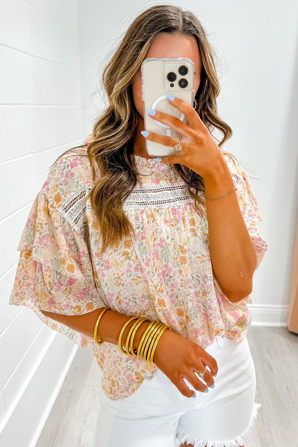 Model confidently walking in a multicolor floral blouse with wide sleeves, paired with jeans (casual outfit).