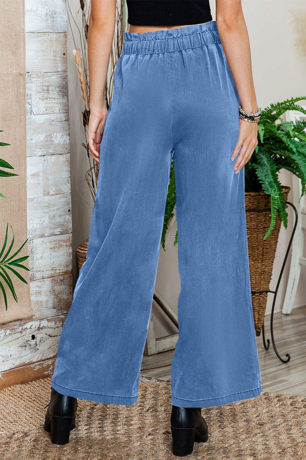 Black high-waisted wide-leg pants styled for a casual brunch date.