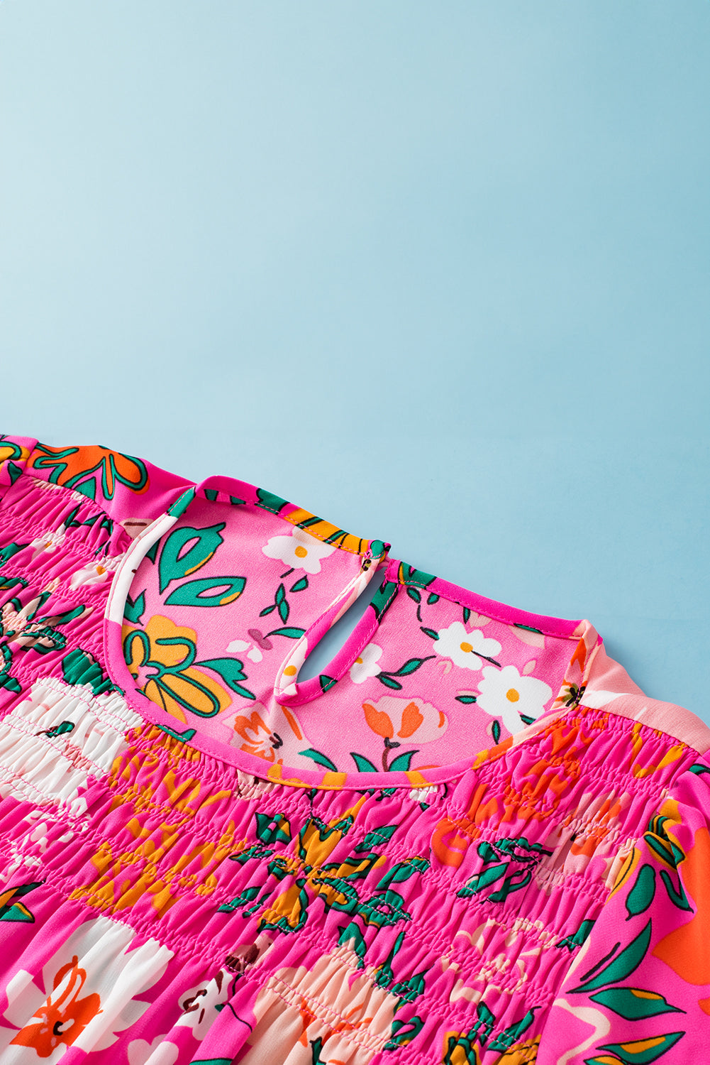 Close-up of the flounce sleeves on the pink floral blouse, highlighting the ruffled design.