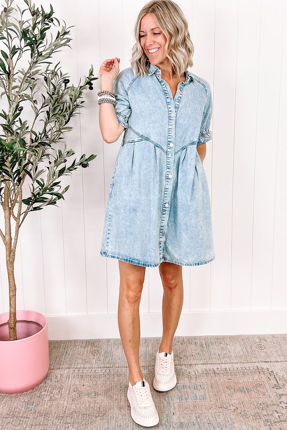 Relaxed fit of the blue mineral washed denim dress through the body (close-up).