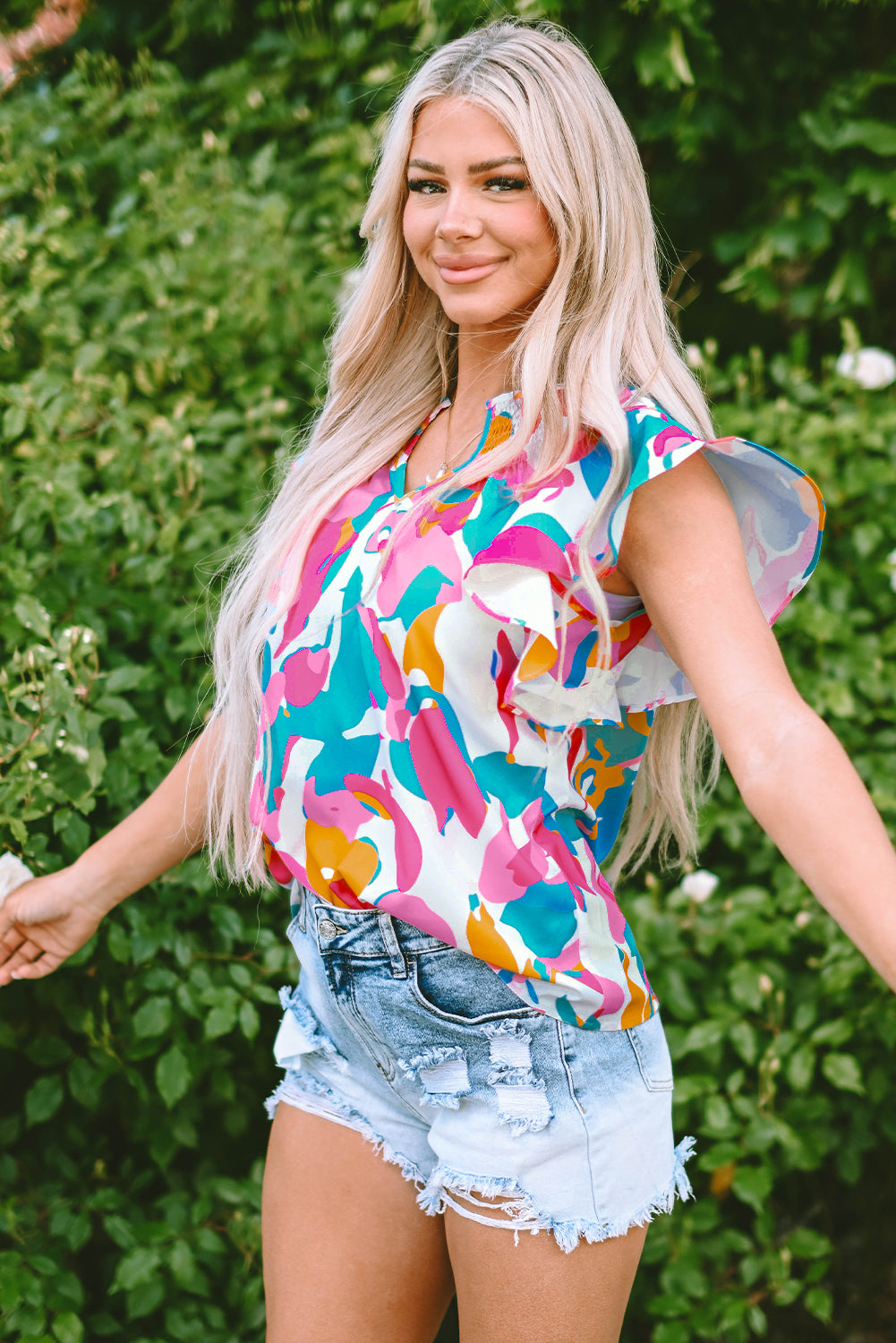 Close-up of the notched neckline with a button closure on the multicolour abstract print blouse 