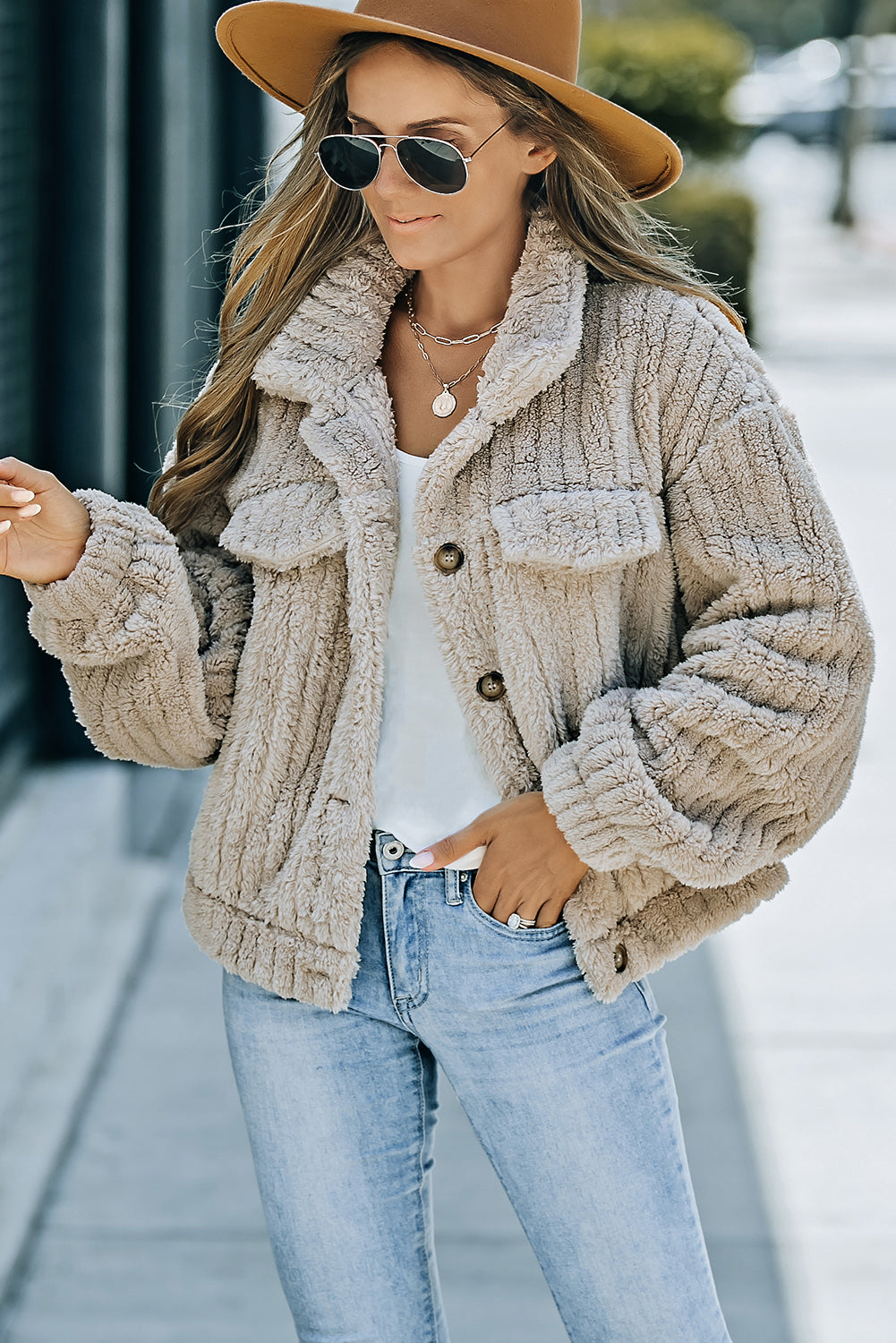 Khaki solid color plush fleece button-up jacket hanging neatly on a hanger.