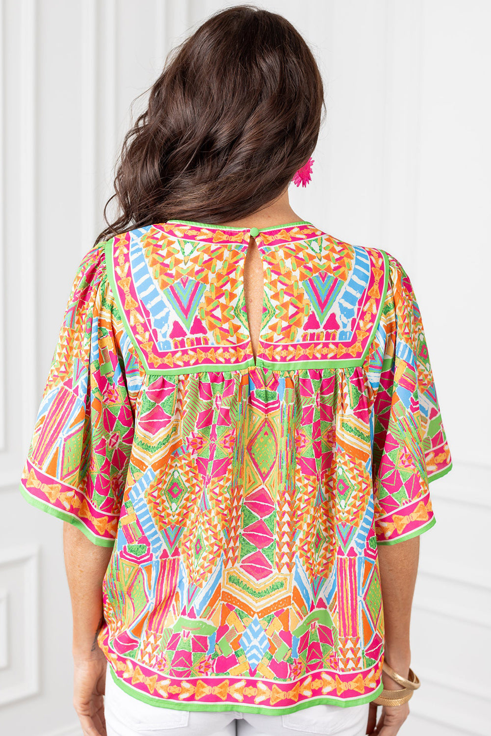 Close-up of the vibrant orange geometric print on the blouse.