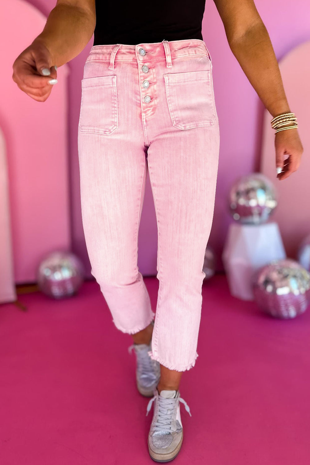 Apricot pink cropped jeans with multiple buttons and a raw edge hem.