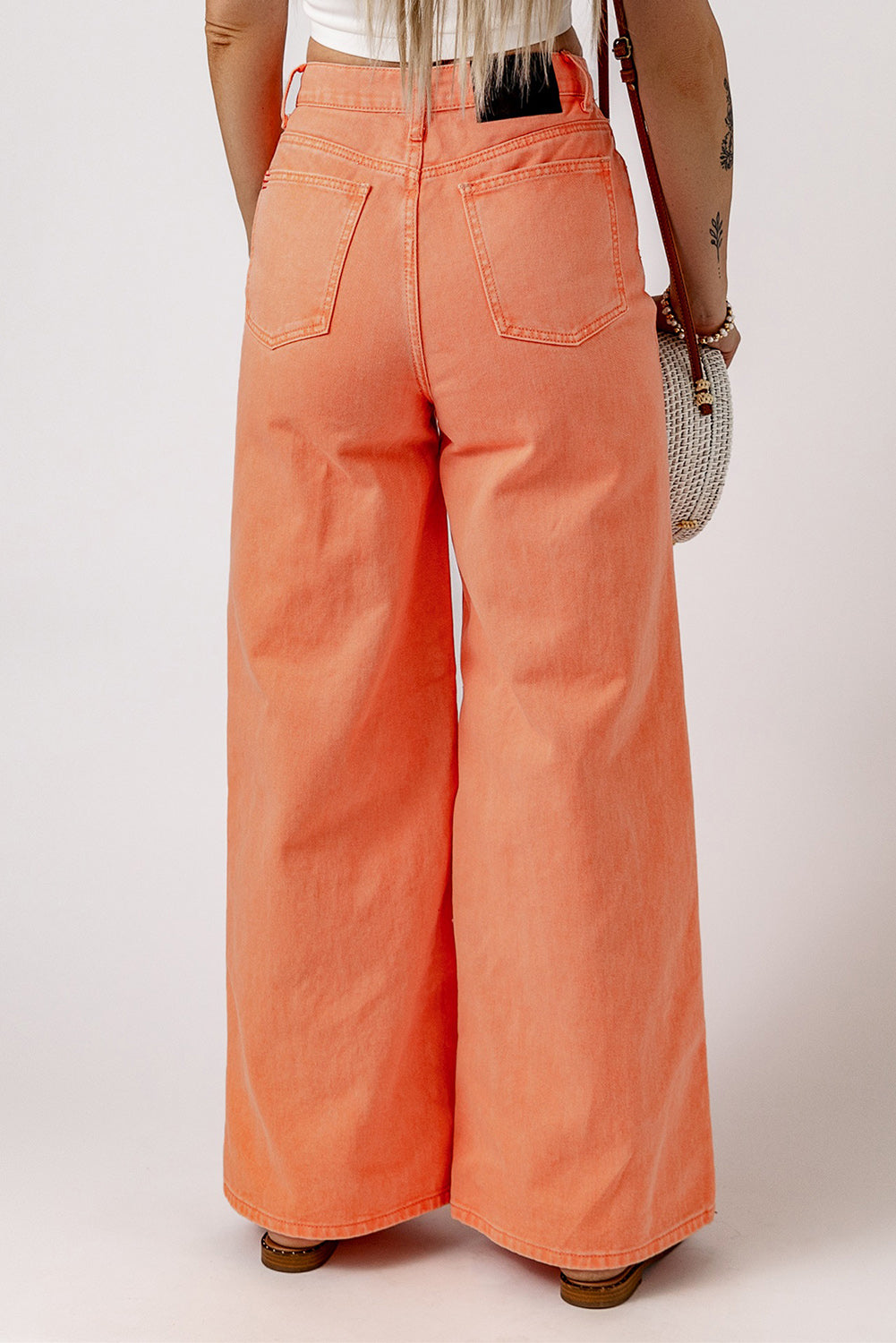 Close-up of the vibrant orange color and acid wash pattern on the jeans.