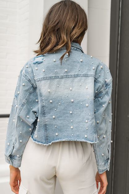 Model wearing a sky blue cropped denim jacket with pearl beading, showcasing the trendy and edgy style (front view).