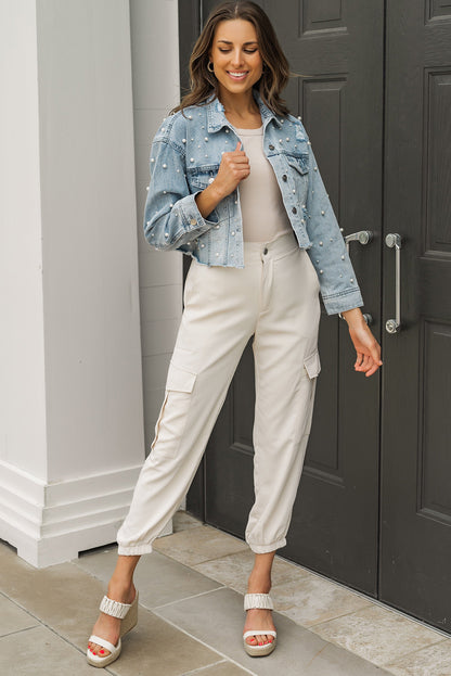 Model with arms raised, showcasing the fit and sleeve length of the cropped denim jacket.