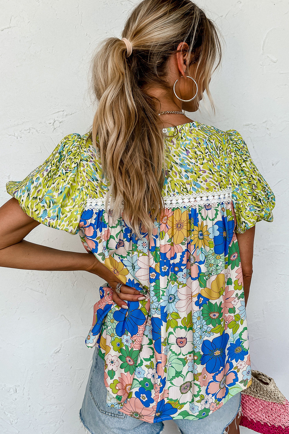 Close-up of the green fabric with a variety of floral patterns on the blouse.