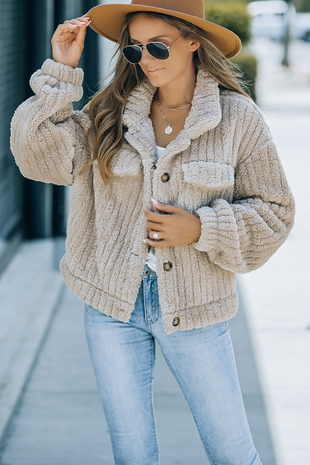 Model walking confidently in a khaki solid color plush fleece button-up jacket.