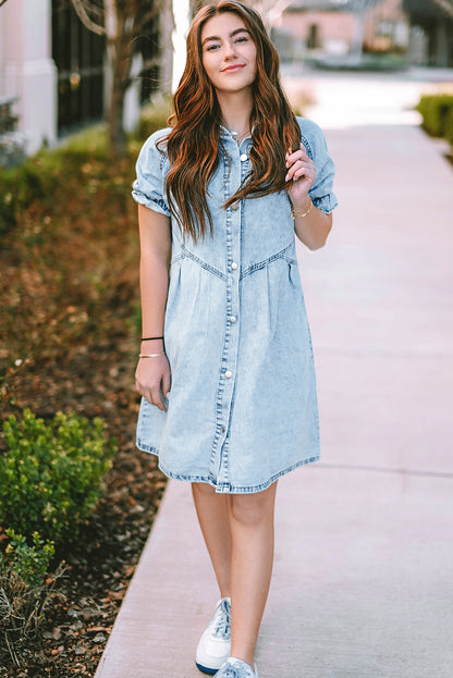 Model wearing the blue mineral washed denim dress with ruffled short sleeves and pockets with a denim jacket for a layered look.