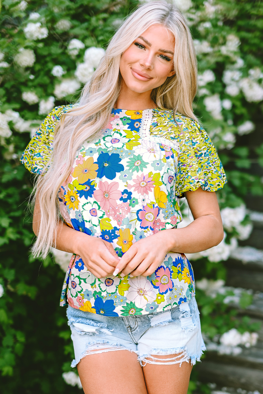 Close-up of the intricate patchwork design featuring mixed floral prints on the green blouse.