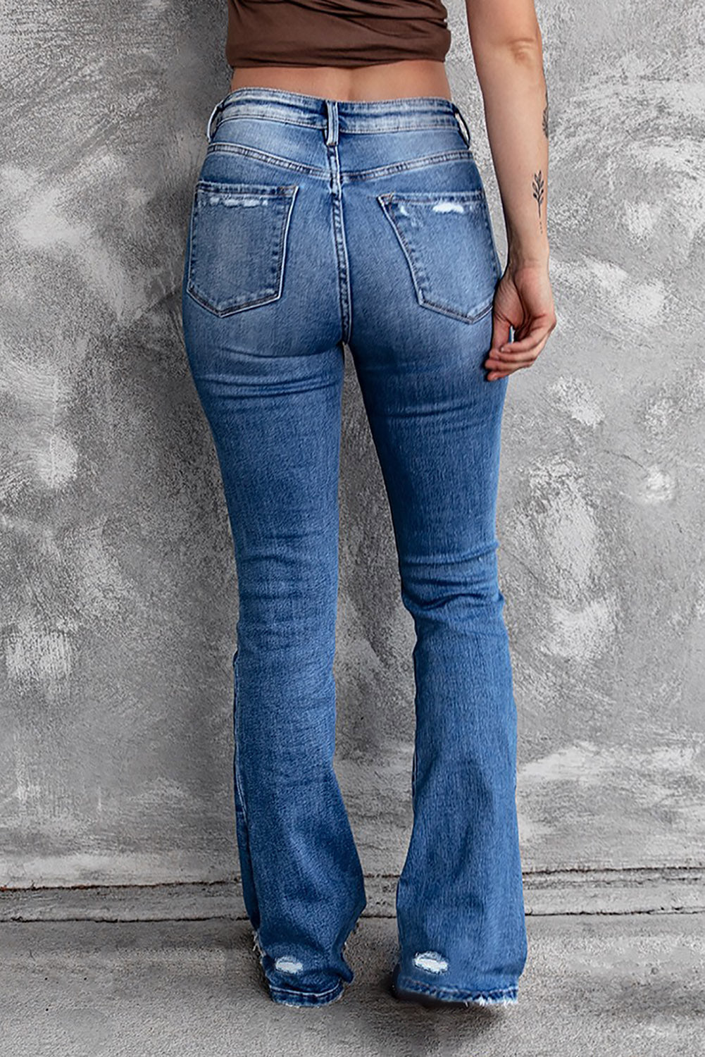 Close-up of the dark wash with ripped and distressed details on the high waist flare jeans.