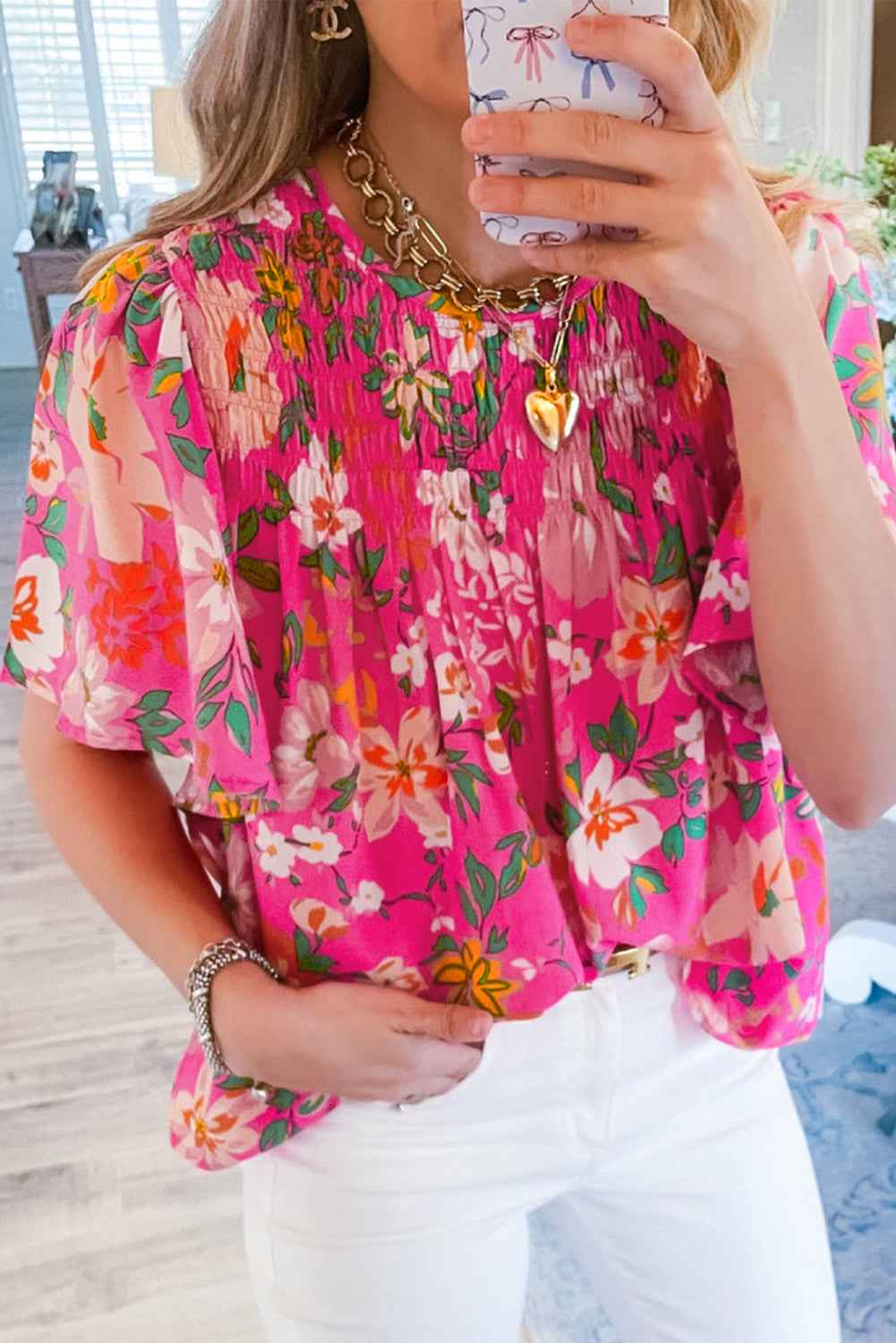 Close-up of the vibrant pink color and delicate floral print on the blouse.