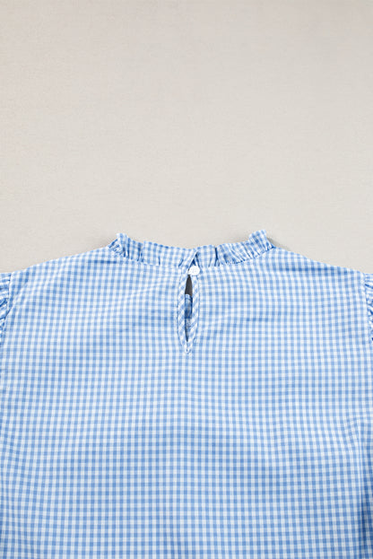 Model wearing the light blue gingham blouse tucked into pants or a skirt, showcasing its versatility.