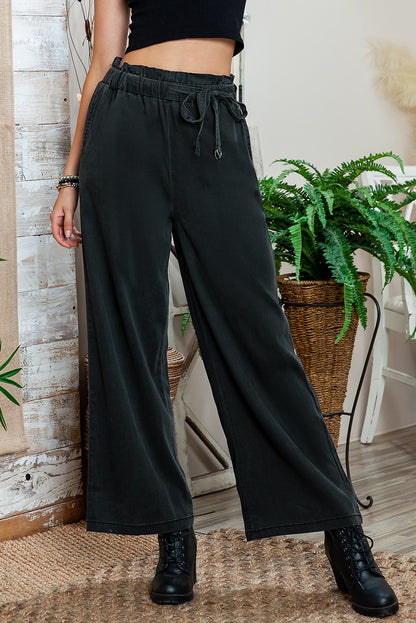 Close-up of functional pockets on black high-waisted pants. 