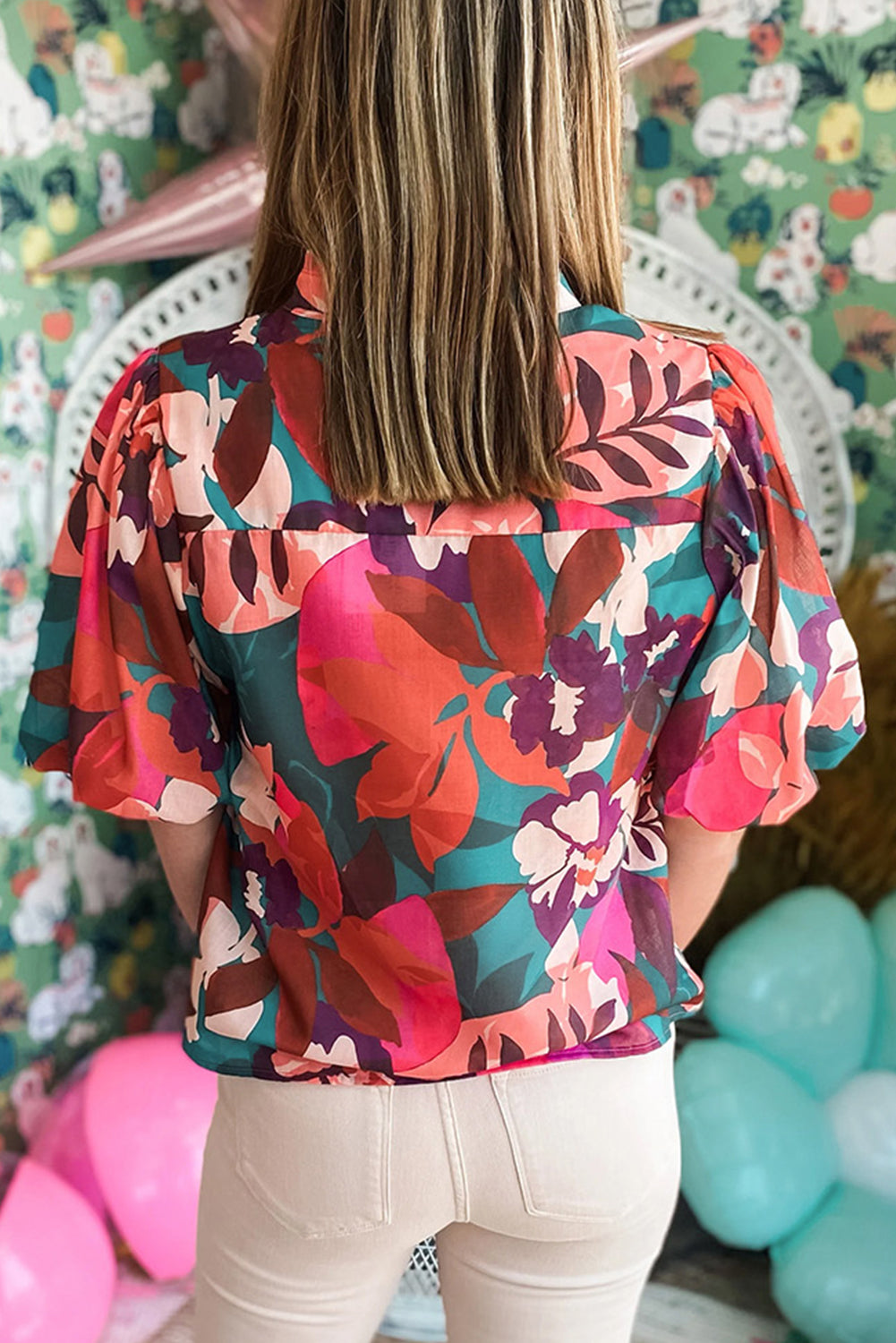 Model wearing a rose red floral print v-neck blouse with lantern sleeves, showcasing the romantic and flowy style (front view).