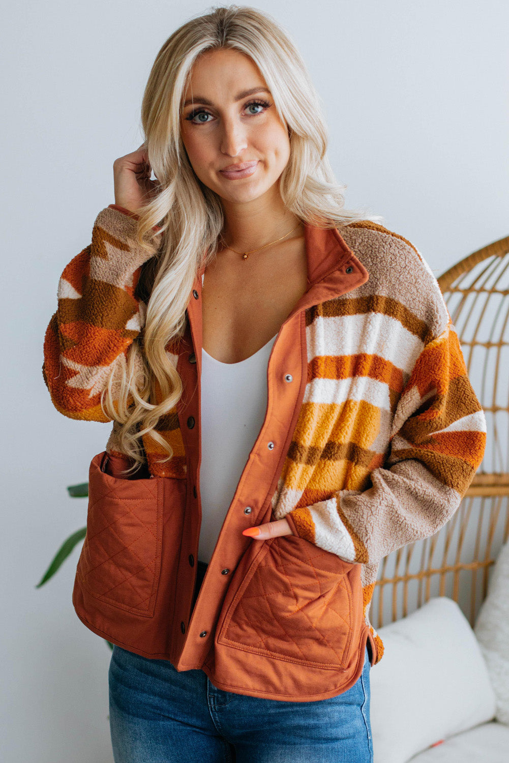 The soft and cozy fleece material of the brown striped and geometric jacket (close-up).